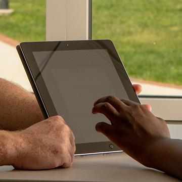 Ohio Information Technologies worker helping with a tablet issue.